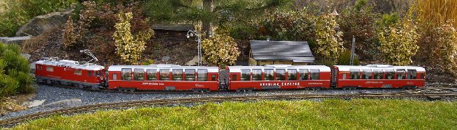 Rychlík RhB s lokomotivou Ge 4/4 II a panoramatickými vozy ve stanici »Susch« na modelovém kolejišti.