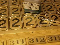 Příprava na černění štítků pro osobní vagony.