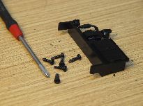 Odejmutý výlisek přístrojové skříně se šesti vruty upevňujícími karoserii.