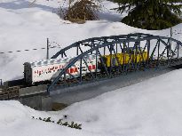 Model na mostě přes zamrzlý potok.