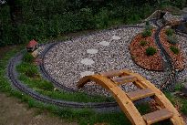 Celkový pohled na západní část kolejiště. V popředí lávka pro bezpečný vstup do „areálu“,  vlevo na snímku stavědlo Západ, vpravo pak železný obloukový most vlastní konstrukce, střední zemní val a v pozadí dřevěný most (opět vlastní volné konstrukce) a ještě ne zcela dokončený tunel.