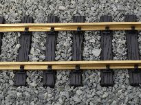 Dřevěné pražce ve štěrkovém poli.