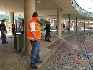 Hasiči umývají olej z chodníku. Foto © Martin Šiler.