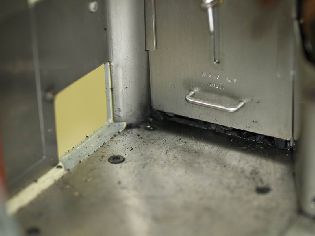 Výsuvná dvířka uhelného bunkru v kabině a čisticí poklop (vlevo).