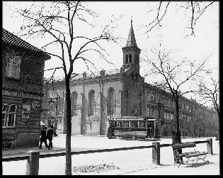 Překrásný snímek vozu evid. č. 7 jedoucího po Ferdinandově třídě směrem na Bory. Vůz se nachází u dodnes stojícího kostelíku na rohu Ferdinandovy a Smetanových sadů. Neznámý fotograf zachytil jedinečnou atmosféru české Plzně. Typické je množství českých nebo česko – německých nápisů (čeština je vždy na prvním místě), což v jiných našich městech v té době nebylo příliš obvyklé. Motorový vůz je v původním stavu. Při pohledu na jeho obsazení zjistíme, že prostor nástupních plošin byl zřejmě velmi oblíben. Snímek byl pořízen v letech 1899—1901. Skleněný negativ 13 × 18 cm uložen v ŽČM, sig. NMP 670.